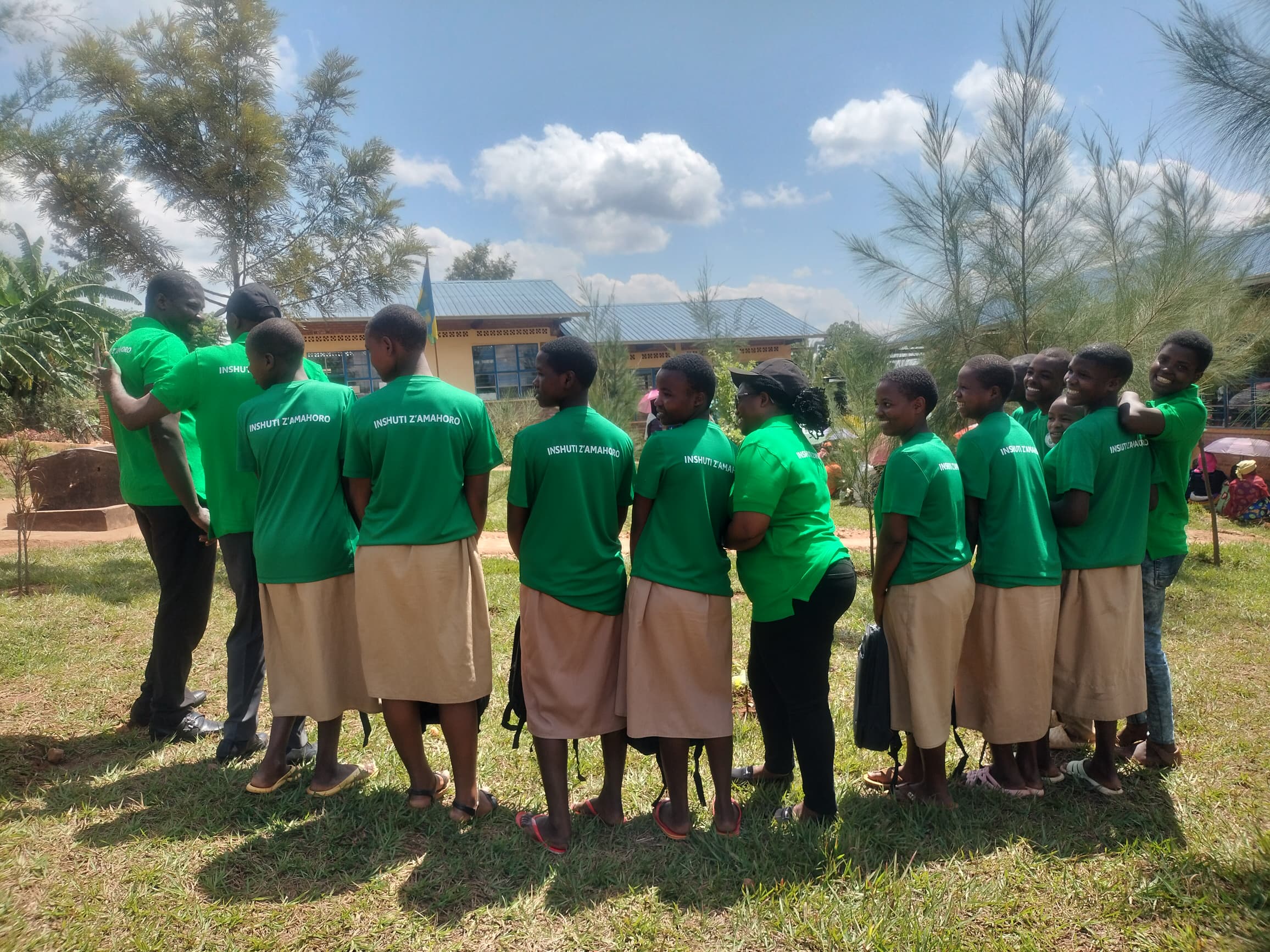Smiling children receiving new school uniforms.